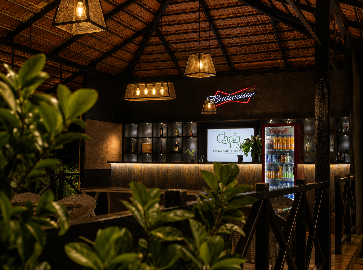 The Chafa bar at night, lit warmly under a thatched roof